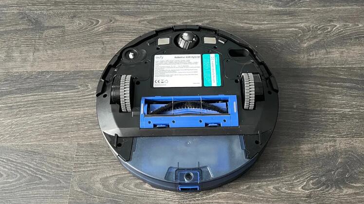 Eufy RoboVac G30 Hybrid upside down on a wooden floor without the mopping pad attached